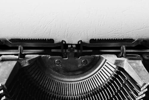 Black and white image of a typewriter with blank page to symbolize copywriting.